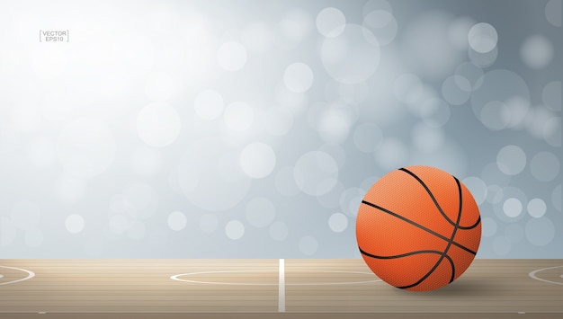 Basketball ball on wooden court area.