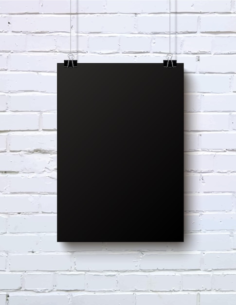 Black blank vertical piece of paper on the white brick wall