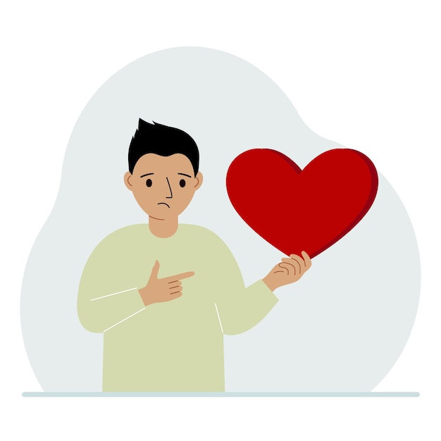 A boy holds a big red heart in his hand The concept of volunteering romantic relationship or love