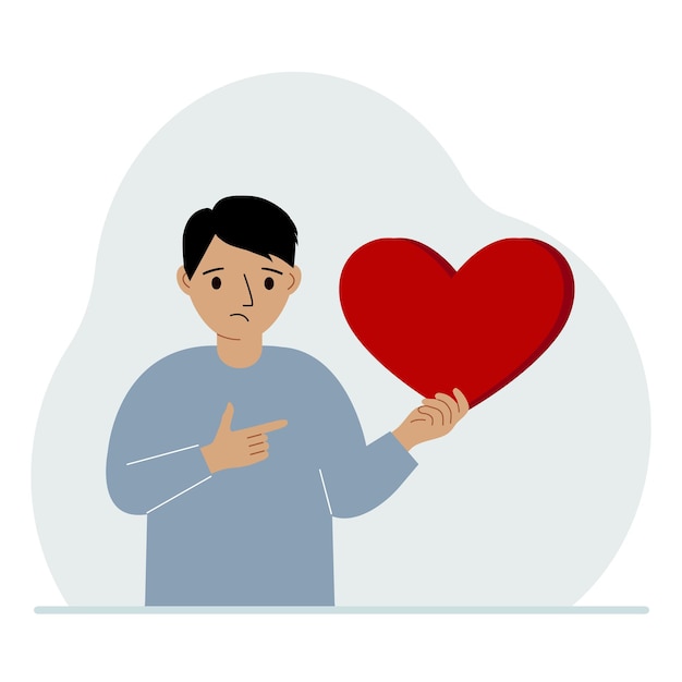 A boy holds a big red heart in his hand The concept of volunteering romantic relationship or love