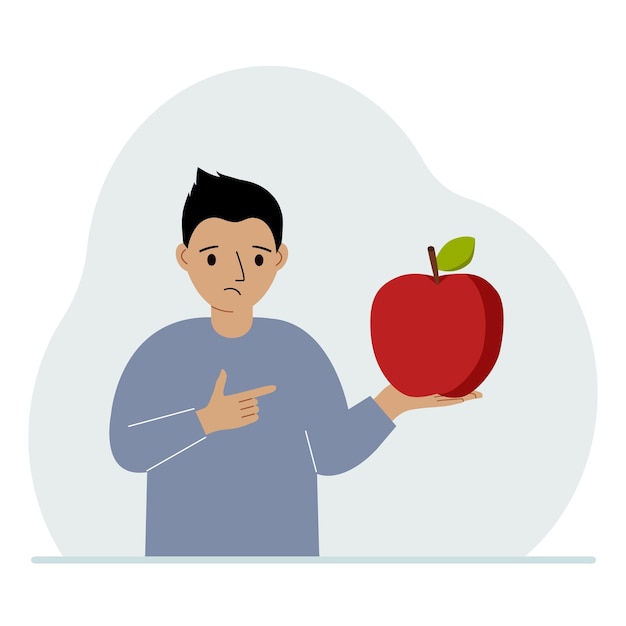 A boy holds a fresh and red apple in his hand Boy eats an apple Healthy food concept