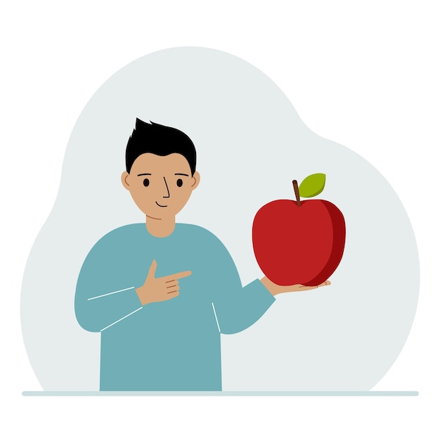 A boy holds a fresh and red apple in his hand Boy eats an apple Healthy food concept