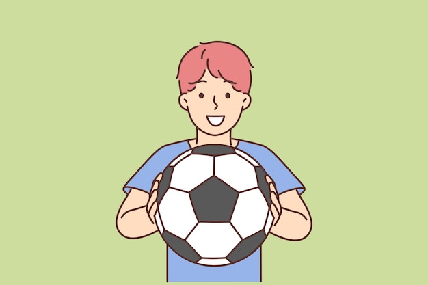 Cheerful boy of school age holding soccer ball and smiling offers to play football