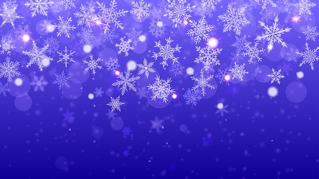 Christmas background of complex blurred and clear falling snowflakes in blue colors with bokeh effect