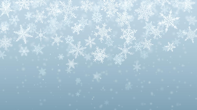 Christmas background of complex blurred and clear falling snowflakes in light blue colors with bokeh effect