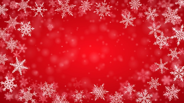 Christmas background of complex blurred and clear falling snowflakes in red colors with bokeh effect