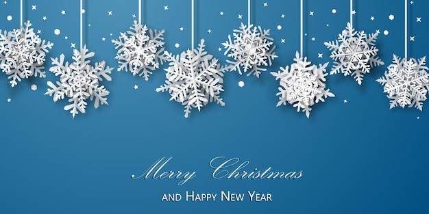 Christmas background of paper snowflakes with soft shadows, white on light blue background