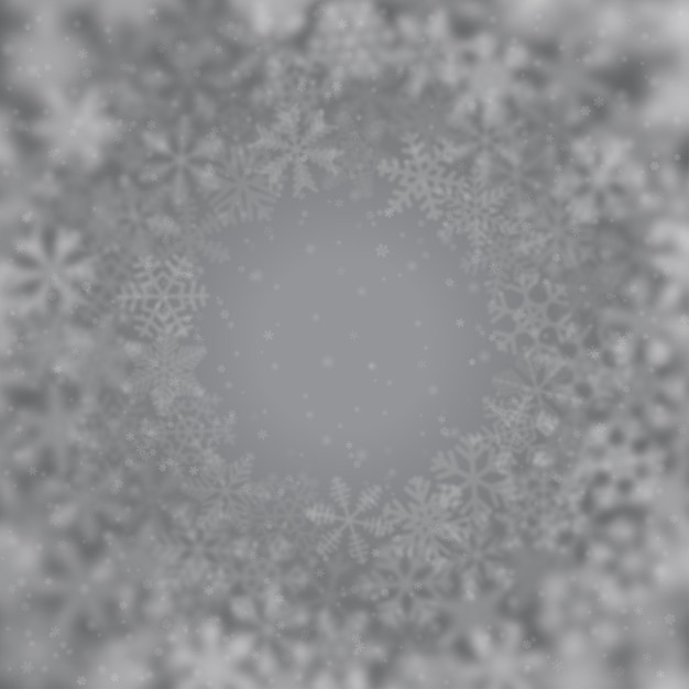 Christmas background of snowflakes of different shape blur and transparency arranged in a circle on gray background