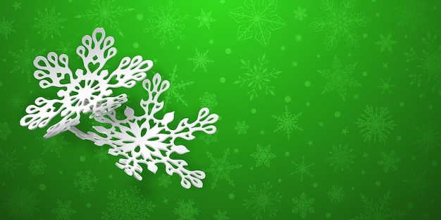 Christmas background with two curved paper snowflakes with soft shadows on green background