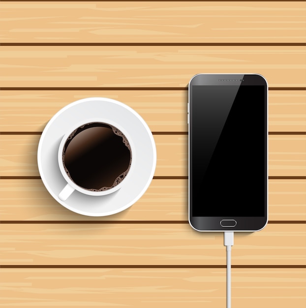 Coffee cup and smartphone on wooden table