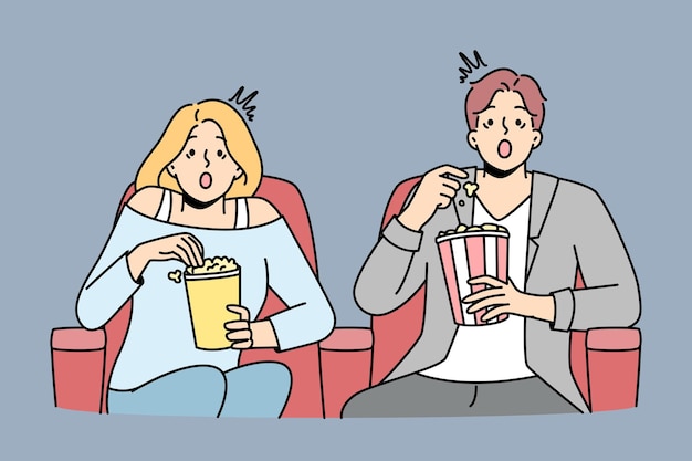 Couple eat popcorn sitting in cinema