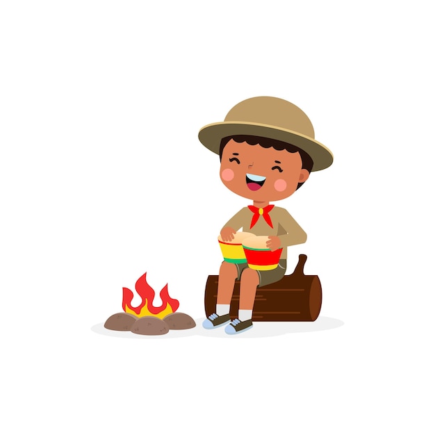 Cute little african kid playing bongo drums boy scout or girl scout sitting on log by the campfire