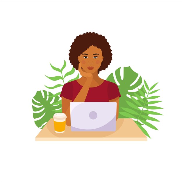 Dark skinned girl sitting at the table with laptop Tropical leaves on background Freelance worker