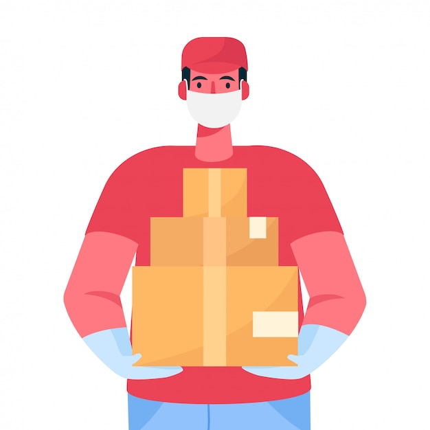 A delivery man in protective medical face mask and gloves holds a cardboard boxes in his hands