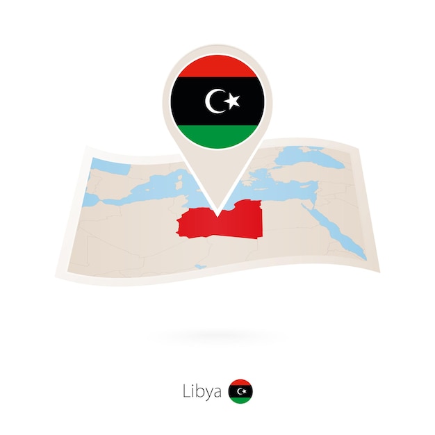 Folded paper map of Libya with flag pin of Libya