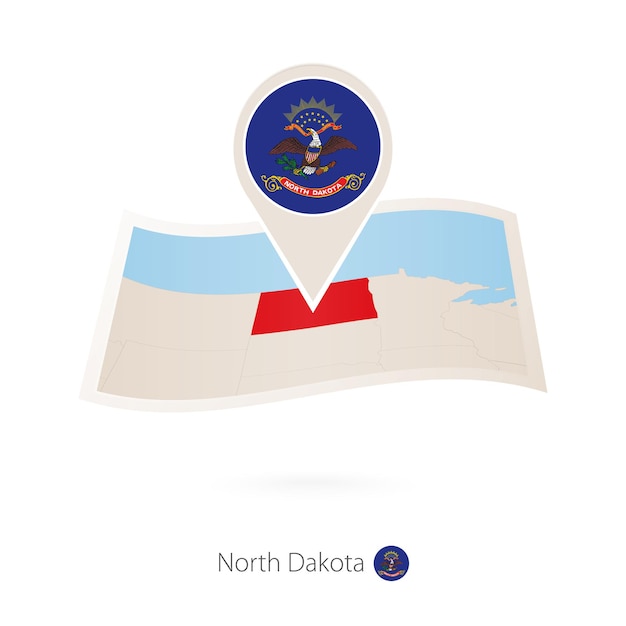 Folded paper map of North Dakota US State with flag pin of North Dakota