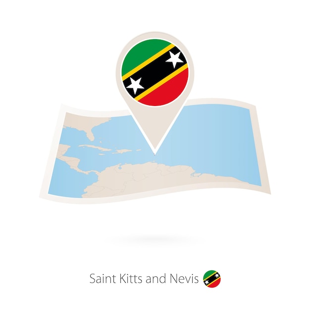 Folded paper map of Saint Kitts and Nevis with flag pin of Saint Kitts and Nevis