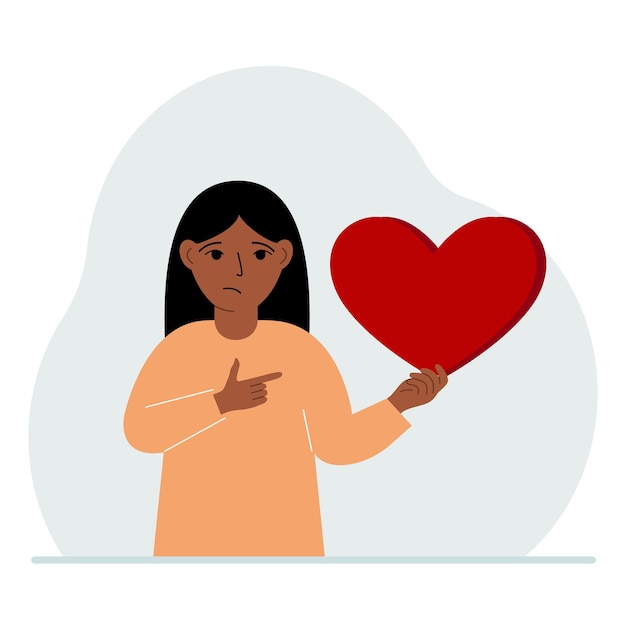 A girl holds a big red heart in his hand The concept of volunteering romantic relationship or love