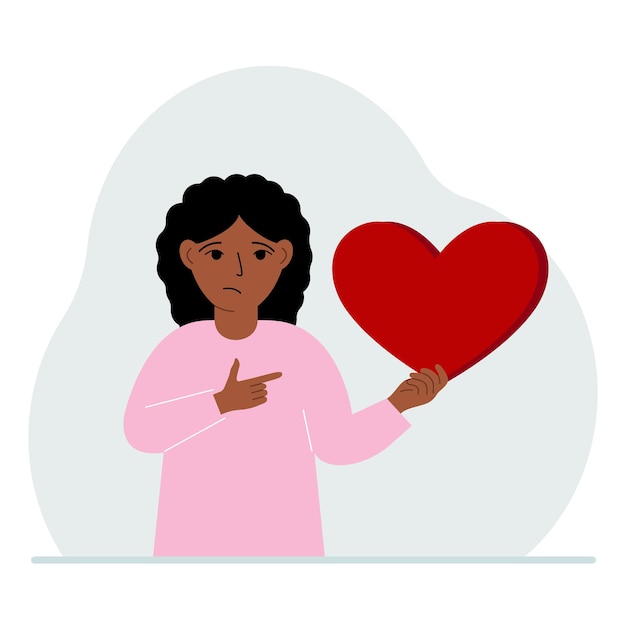 A girl holds a big red heart in his hand The concept of volunteering romantic relationship or love