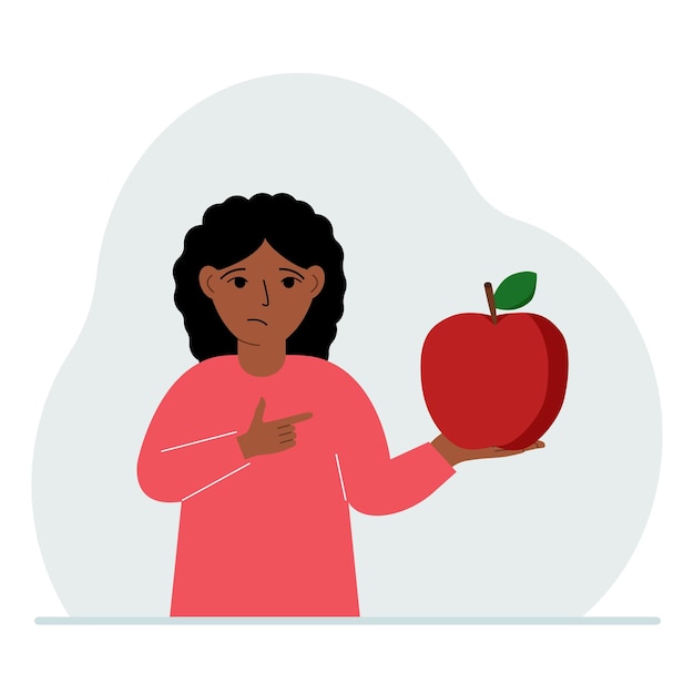 A girl holds a fresh and red apple in his hand Girl eats an apple Healthy food concept