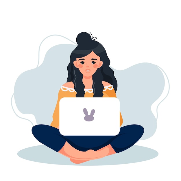 A girl in the lotus position is working on a laptop