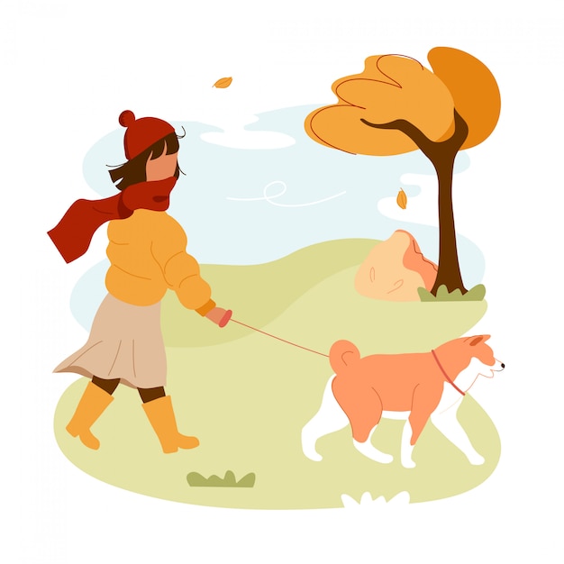 Girl walking dog on leash in park.