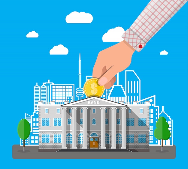 Hand putting coin into bank building