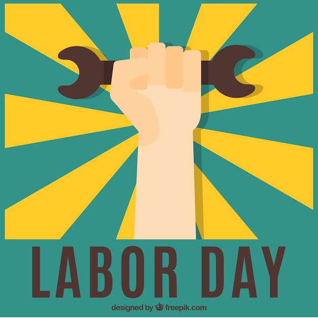 Vector hand with wrench on a sunburst labor day background