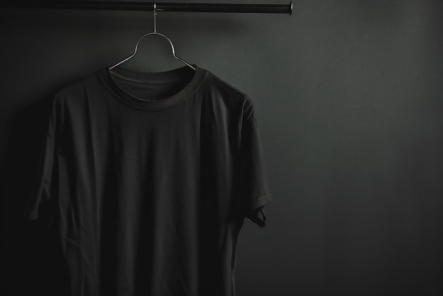 Vector hanger with stylish black tshirt on gray wooden wall