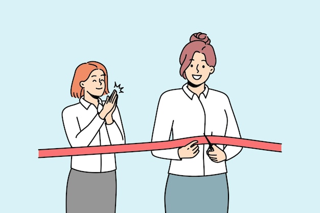 Happy businesswoman cuts red ribbon with scissors