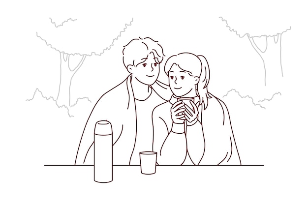 Happy couple sitting in park drinking tea