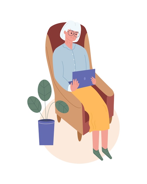 Happy grandma is sitting in an armchair with a laptop Elderly woman spends time on the Internet