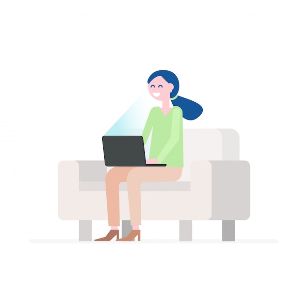 Happy young woman sitting on comfortable couch and using laptop. 