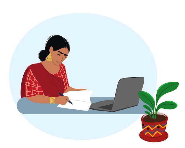 Indian business woman sitting at a table with a laptop and reading a document at the table, looking