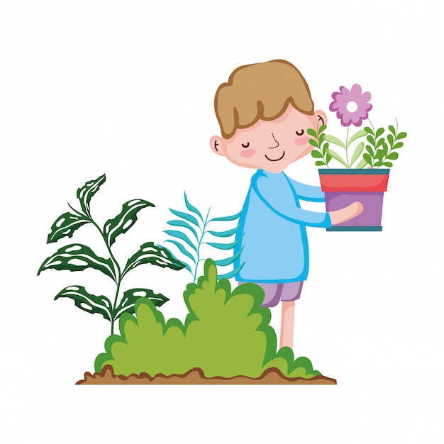 Little boy lifting houseplant in the garden