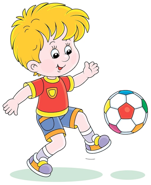 Little football player kicking a colorful ball at a match or training on a sports field