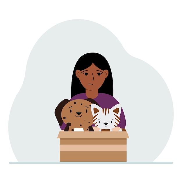 A little girl holds a cardboard box with a cat and a dog The concept of rescue help and care for pets