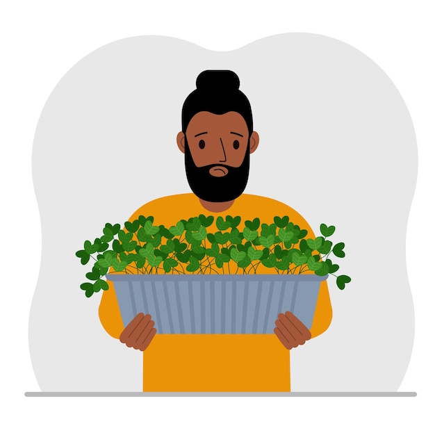 A man holds a pot with a houseplant in his hands Hobby is growing plants and flowers