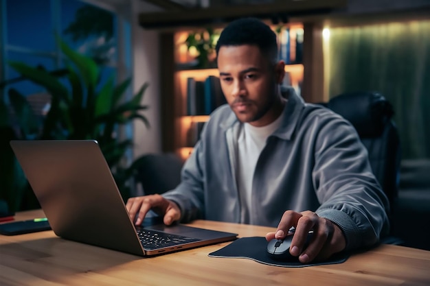 a man sits at a desk with a laptop and a mouse