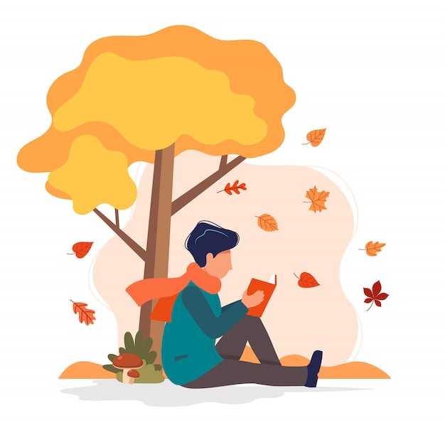 Man sitting with book under the tree in autumn. 