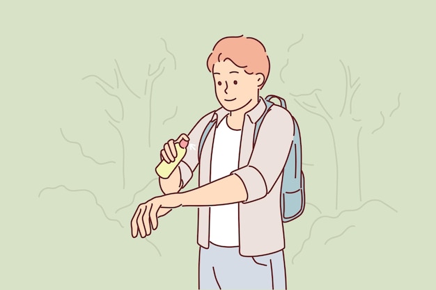 Man uses antimosquito spray while walking in forest or natural park in summer weather