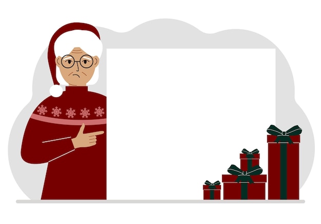 A old woman in a Christmas or New Year's sweater with a red sana cap points his finger at a banner a blank poster or a large white sheet of paper with space for text