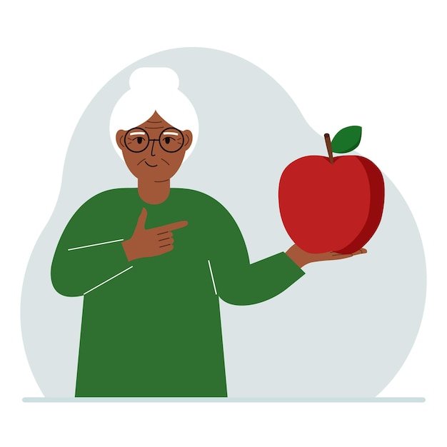 A old woman holds a fresh and red apple in his hand Woman eats an apple Healthy food concept