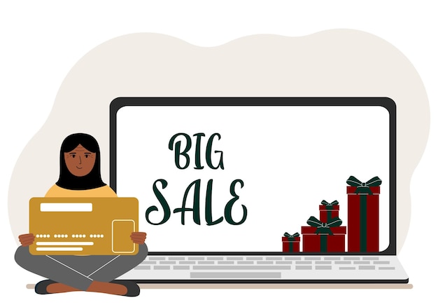 Online shopping Big sale A woman sits crosslegged in his hands holding a shopping card Next to a laptop with gifts