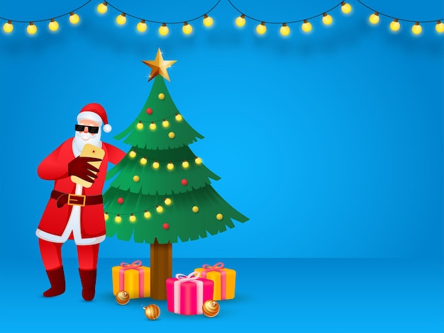 Santa Claus Taking Selfie With Decorative Xmas Tree Golden Baubles Gift Boxes Lighting Garland Decorated On Blue Background And Copy Space