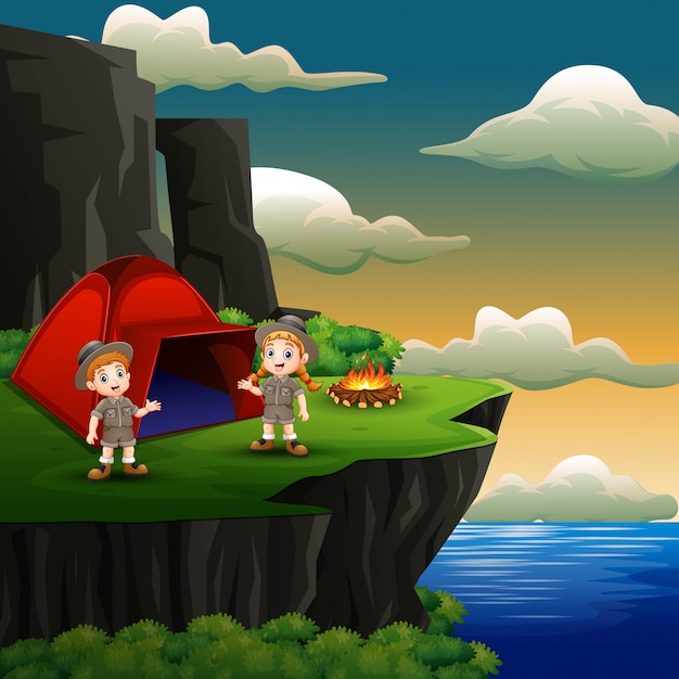 Scout boy and girl are camping on the cliff