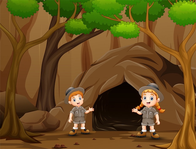 Scout boy and girl talking near the cave