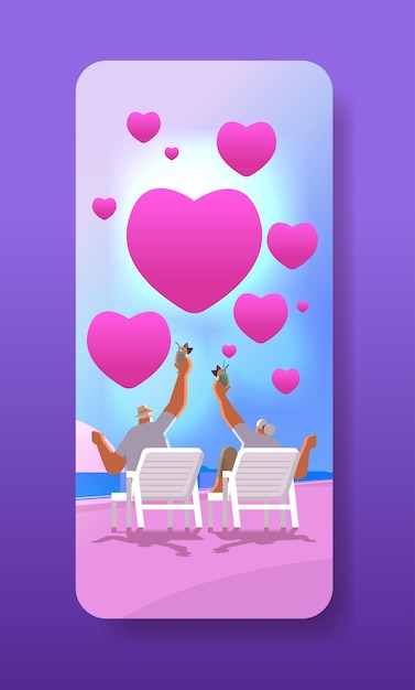 senior man woman drinking cocktails on tropical beach with pink love hearts aged couple celebrating valentines day vertical