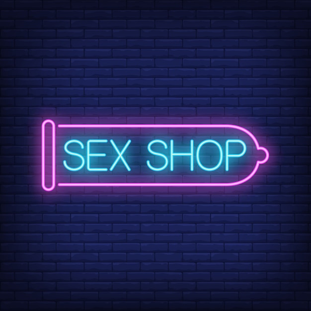 Sex shop neon sign. Pink condom on brick wall. Night bright advertisement. 