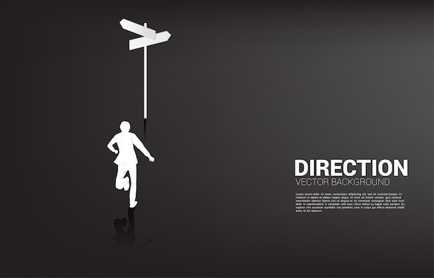 Silhouette of businessman standing at direction signage. Concept of time to make decision in business direction